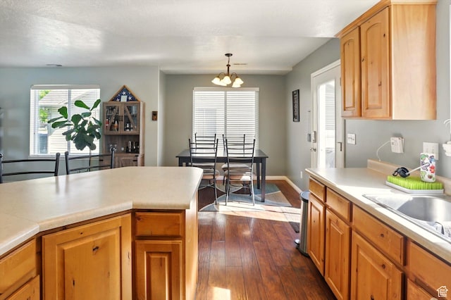 679 S Trail Cir W, Logan, UT 84341 - kitchen with dark wood finished floors, light countertops, a chandelier, pendant lighting, and baseboards