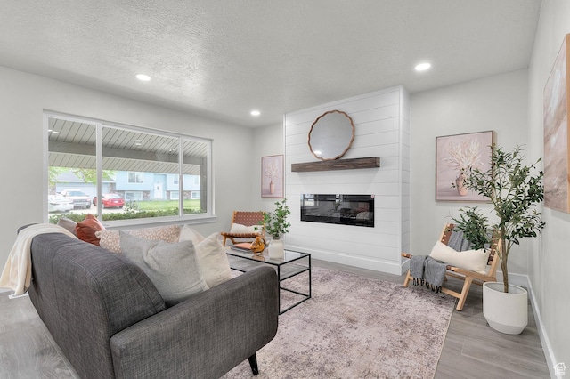 4112 W 5085 S, Kearns, UT 84118 - living room featuring recessed lighting, a fireplace, wood finished floors, baseboards, and a textured ceiling