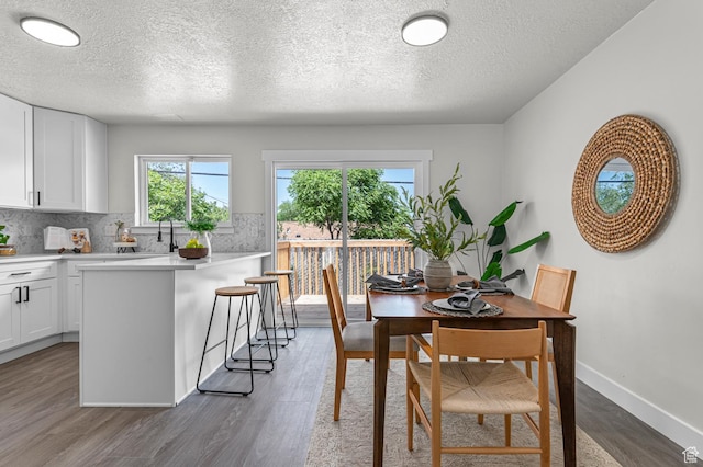 4112 W 5085 S, Kearns, UT 84118 - dining room featuring healthy amount of natural light, dark wood-style floors, a textured ceiling, and baseboards