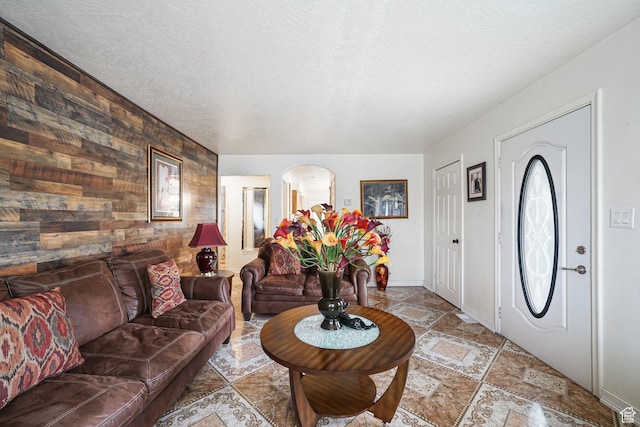 705 N American Beauty Dr, Salt Lake City, UT 84116 - entrance foyer with wood walls, an accent wall, a textured ceiling, arched walkways, and baseboards