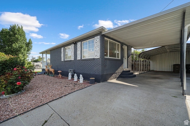 705 N American Beauty Dr, Salt Lake City, UT 84116 - view of property exterior with entry steps, driveway, brick siding, and a carport