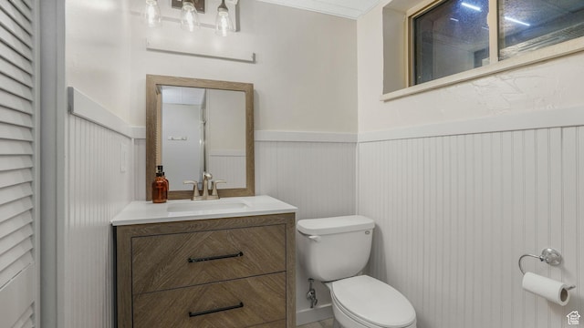 8646 S Spartan Dr, Sandy, UT 84094 - half bathroom featuring toilet, a wainscoted wall, and vanity