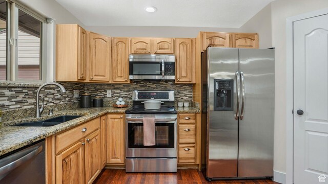 8646 S Spartan Dr, Sandy, UT 84094 - kitchen featuring appliances with stainless steel finishes, a sink, light stone counters, and backsplash