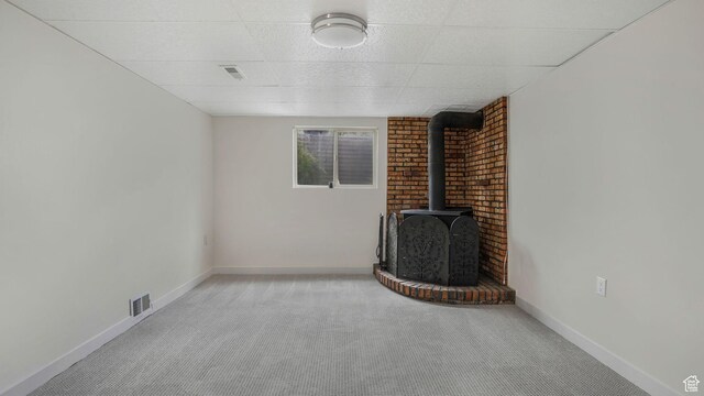 8646 S Spartan Dr, Sandy, UT 84094 - unfurnished living room with a wood stove, carpet flooring, baseboards, and a drop ceiling
