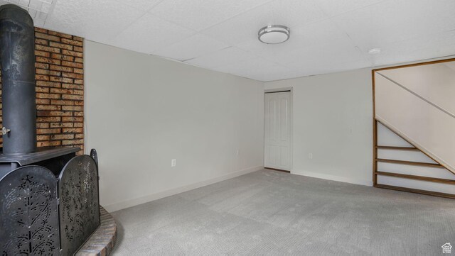 8646 S Spartan Dr, Sandy, UT 84094 - unfurnished living room with carpet flooring, a wood stove, and baseboards