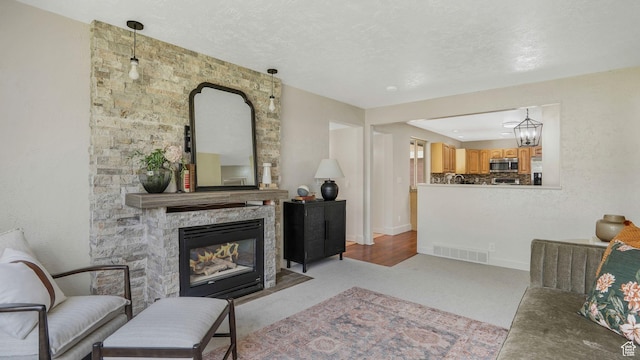 8646 S Spartan Dr, Sandy, UT 84094 - living room with a stone fireplace, light carpet, and baseboards