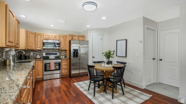 8646 S Spartan Dr, Sandy, UT 84094 - kitchen with appliances with stainless steel finishes, a sink, light stone countertops, dark wood-style flooring, and recessed lighting