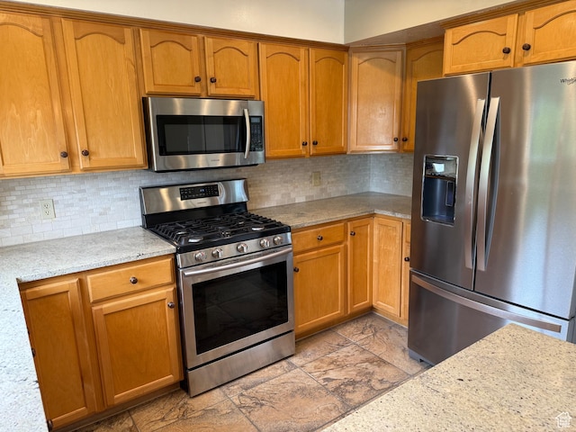 5208 W Case Rd, West Jordan, UT 84081 - kitchen featuring stainless steel appliances, backsplash, brown cabinets, and light stone counters