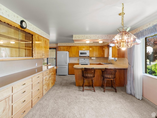 235 E 800 N Unit 2, Tremonton, UT 84337 - kitchen featuring white appliances, light carpet, a chandelier, and light countertops