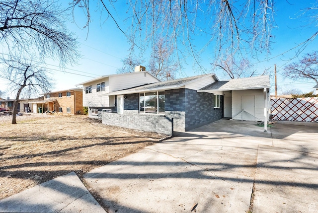 2054 W Mark St, Layton, UT 84041 - tri-level home featuring a chimney, concrete driveway, an attached carport, and brick siding
