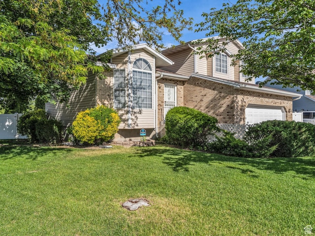 4853 W Ticklegrass Rd, West Jordan, UT 84081 - view of front facade with a front lawn, brick siding, and an attached garage