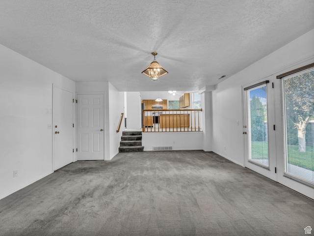 4853 W Ticklegrass Rd, West Jordan, UT 84081 - unfurnished living room featuring carpet, stairs, a textured ceiling, and baseboards