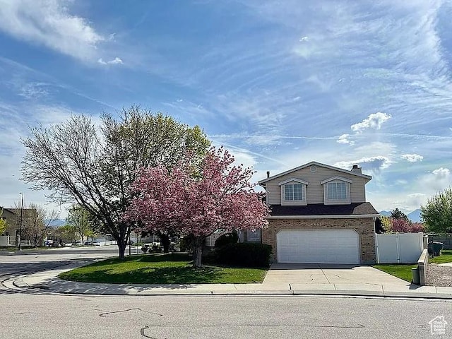 4853 W Ticklegrass Rd, West Jordan, UT 84081 - view of front facade with driveway, an attached garage, and brick siding