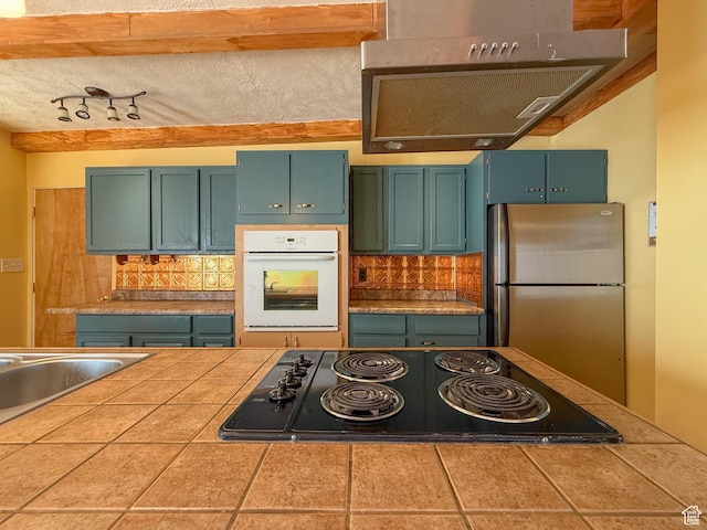 775 N 500 E, Price, UT 84501 - kitchen featuring white oven, black electric stovetop, freestanding refrigerator, tasteful backsplash, and tile counters