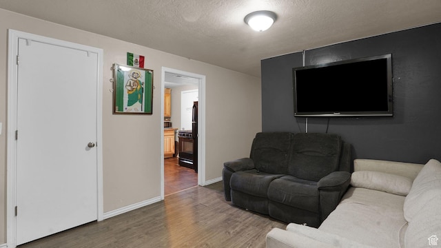 6828 W Copperhill Dr, West Valley City, UT 84128 - living room featuring wood finished floors, a textured ceiling, and baseboards