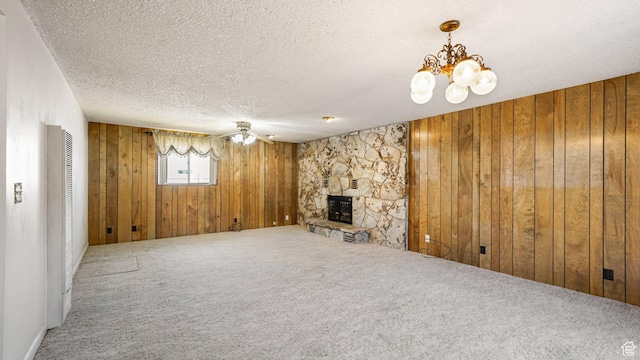 374 N 500 E, Spanish Fork, UT 84660 - unfurnished living room featuring wood walls, a textured ceiling, carpet flooring, a fireplace, and a chandelier