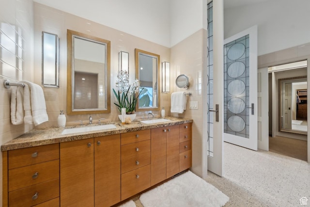 2067 E Pheasant Cir, Holladay, UT 84121 - bathroom featuring double vanity, speckled floor, and tile walls
