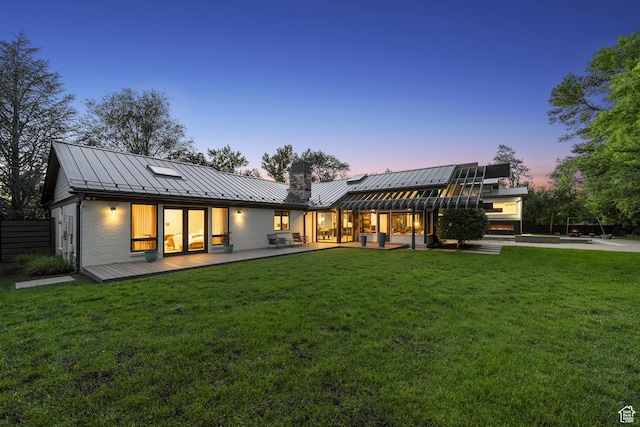 2067 E Pheasant Cir, Holladay, UT 84121 - back of property at dusk with a standing seam roof, metal roof, and a lawn