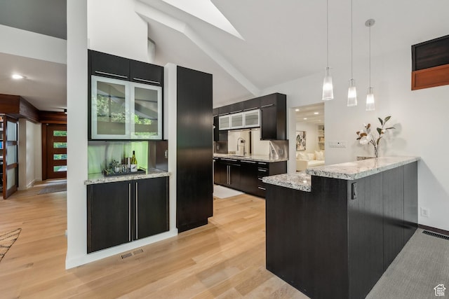 2067 E Pheasant Cir, Holladay, UT 84121 - kitchen with hanging light fixtures, light wood-style flooring, a peninsula, glass insert cabinets, and light stone countertops