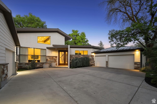 2067 E Pheasant Cir, Holladay, UT 84121 - contemporary home featuring stone siding, a standing seam roof, a detached garage, and metal roof