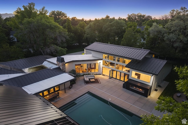 2067 E Pheasant Cir, Holladay, UT 84121 - back of house featuring a standing seam roof, metal roof, outdoor lounge area, an outdoor pool, and a patio