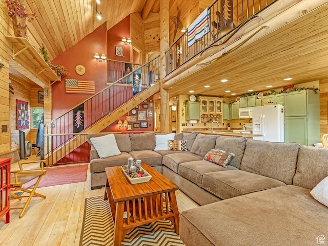 9281 N Uinta Dr, Oakley, UT 84055 - living area with high vaulted ceiling, wood ceiling, light wood-type flooring, stairs, and wood walls