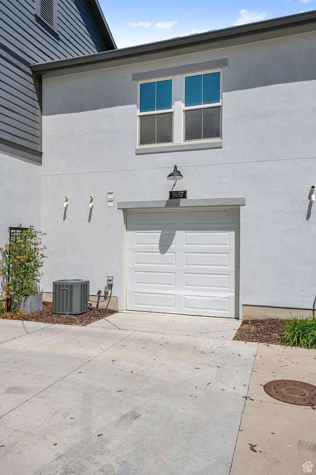 5957 W Lake Ave, South Jordan, UT 84009 - view of property exterior with central AC unit, a garage, stucco siding, and driveway
