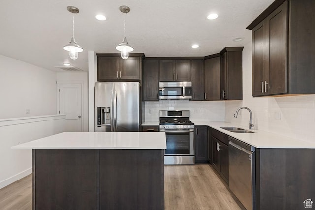 5957 W Lake Ave, South Jordan, UT 84009 - kitchen with appliances with stainless steel finishes, a sink, dark brown cabinetry, light wood-style floors, and recessed lighting