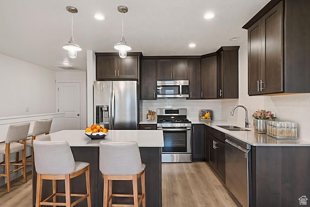 5957 W Lake Ave, South Jordan, UT 84009 - kitchen featuring appliances with stainless steel finishes, a sink, light wood finished floors, dark brown cabinetry, and tasteful backsplash
