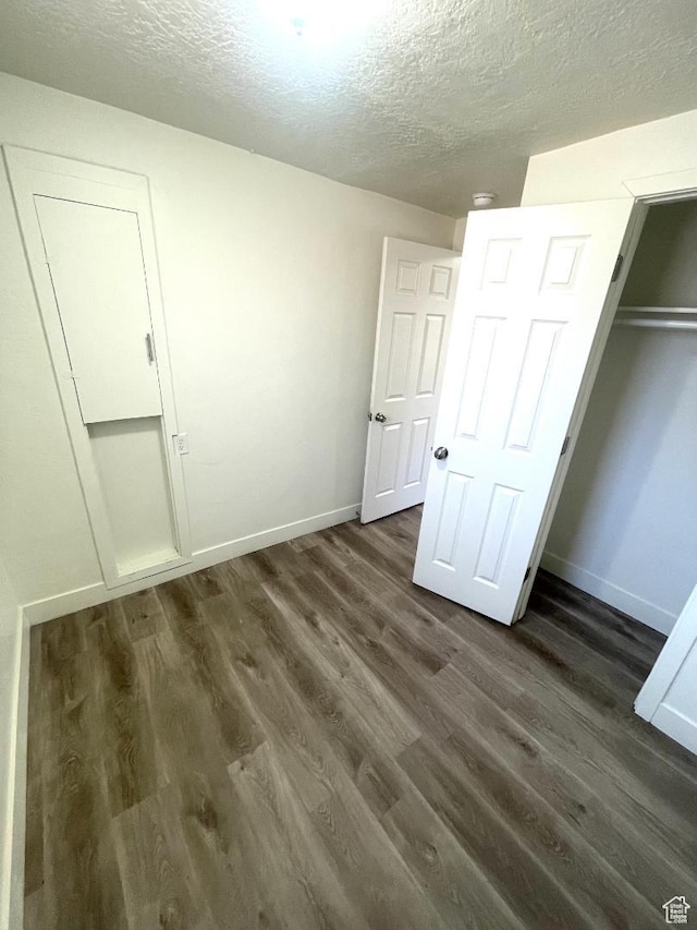 751 E Scott Ave, Millcreek, UT 84106 - unfurnished bedroom with a textured ceiling, dark wood-style floors, baseboards, and a closet