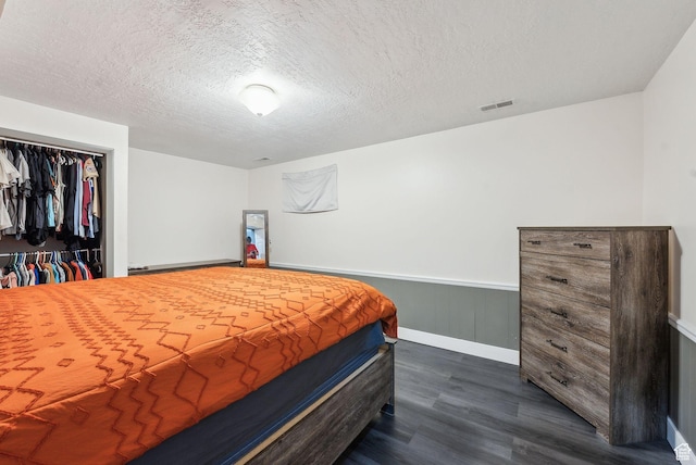 981 N Tremont St, Tremonton, UT 84337 - bedroom featuring dark wood-style flooring, wainscoting, a textured ceiling, baseboards, and a closet