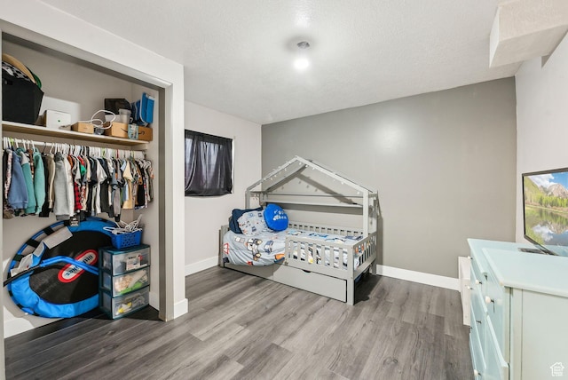 981 N Tremont St, Tremonton, UT 84337 - bedroom with wood finished floors, baseboards, a textured ceiling, and a closet