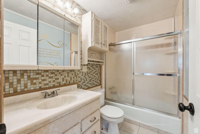 981 N Tremont St, Tremonton, UT 84337 - bathroom with a textured ceiling, shower / bath combination with glass door, vanity, toilet, and tile patterned floors