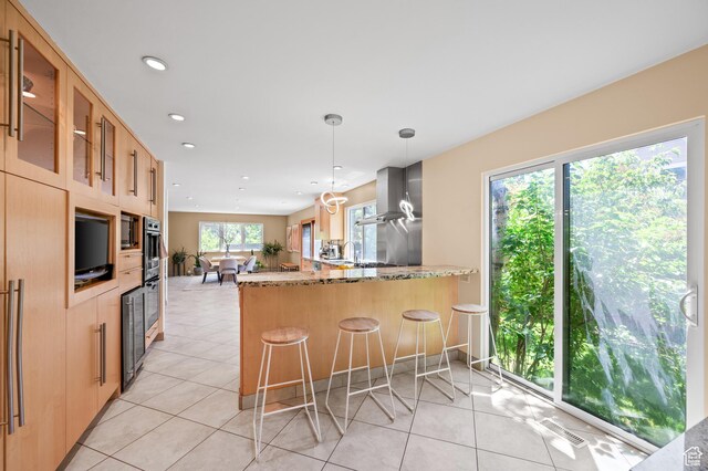 8848 S Willow Hills Ct, Sandy, UT 84093 - kitchen featuring light stone countertops, glass insert cabinets, wall chimney exhaust hood, a peninsula, and recessed lighting