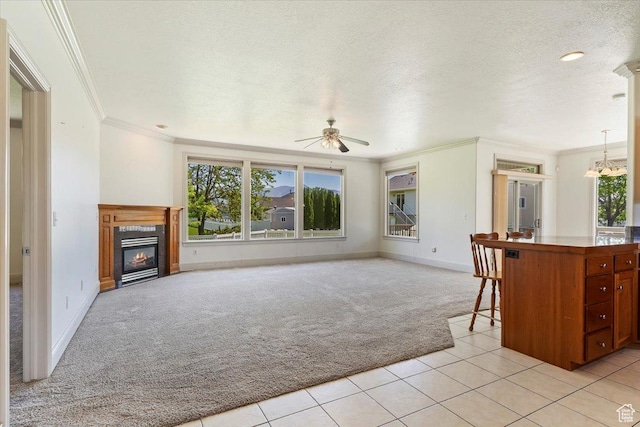 3524 N 3000 W, Farr West, UT 84404 - unfurnished living room featuring light carpet, healthy amount of natural light, crown molding, a ceiling fan, and a glass covered fireplace