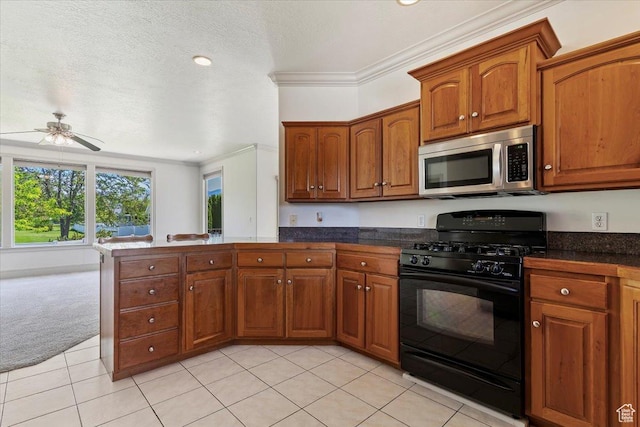 3524 N 3000 W, Farr West, UT 84404 - kitchen featuring stainless steel microwave, black gas stove, a peninsula, brown cabinets, and crown molding