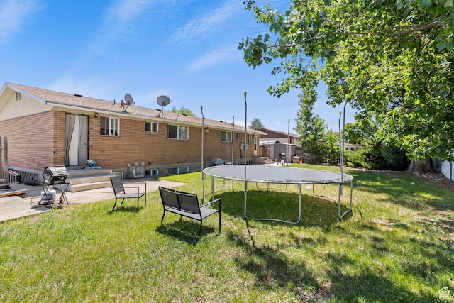 285 N 300 W, Orem, UT 84057 - rear view of property featuring a trampoline, brick siding, and a lawn