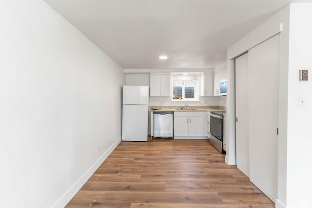 285 N 300 W, Orem, UT 84057 - kitchen with appliances with stainless steel finishes, a sink, white cabinetry, wood finished floors, and light countertops