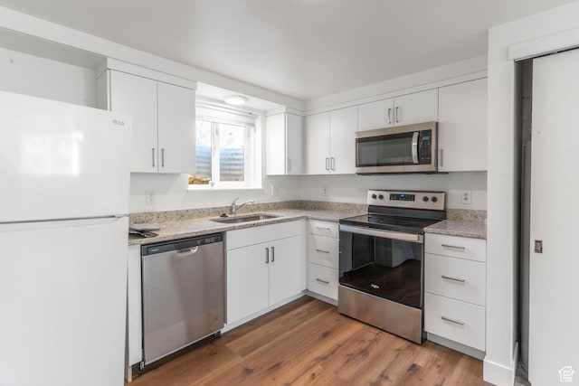 285 N 300 W, Orem, UT 84057 - kitchen featuring stainless steel appliances, a sink, white cabinets, wood finished floors, and light stone countertops