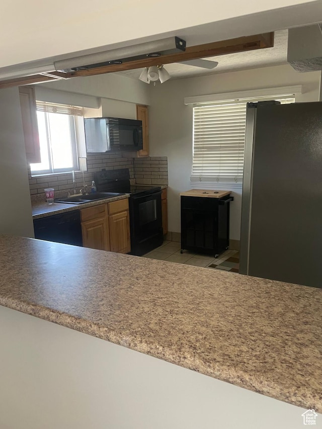 5890 S 2625 W, Roy, UT 84067 - kitchen with black appliances, decorative backsplash, light tile patterned floors, a ceiling fan, and light countertops