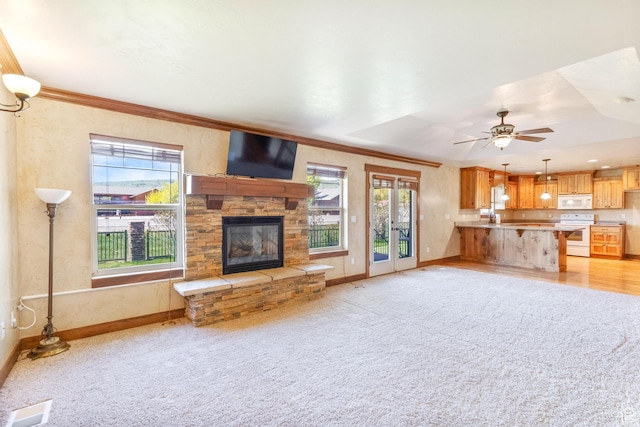 2029 S Cottage Ln, Garden City, UT 84028 - unfurnished living room featuring healthy amount of natural light, a fireplace, baseboards, and crown molding