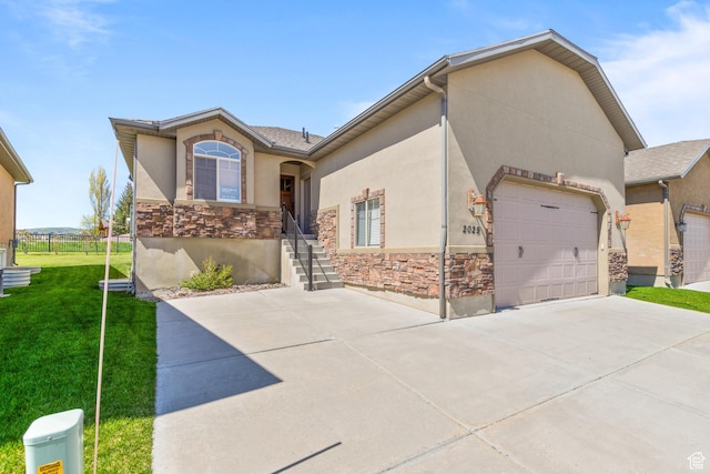 2029 S Cottage Ln, Garden City, UT 84028 - view of front of house with stone siding, driveway, a garage, and stucco siding