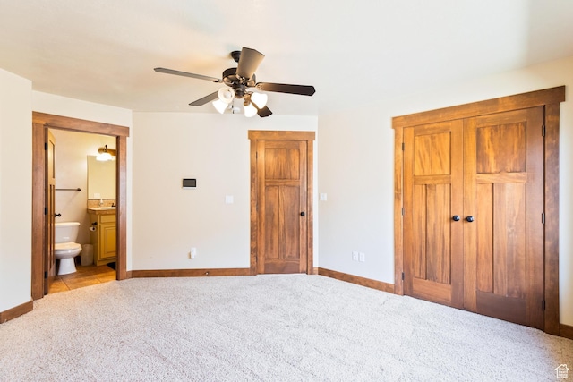 2029 S Cottage Ln, Garden City, UT 84028 - unfurnished bedroom featuring light colored carpet, baseboards, ensuite bath, ceiling fan, and a sink