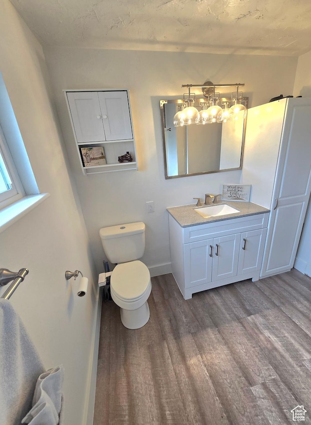 1191 N Geneva Rd, Provo, UT 84601 - bathroom with wood finished floors, vanity, toilet, a chandelier, and baseboards