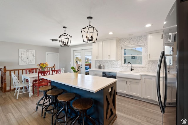 1265 W 1625 S, Syracuse, UT 84075 - kitchen with freestanding refrigerator, a sink, a breakfast bar, light countertops, and white cabinets