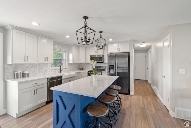 1265 W 1625 S, Syracuse, UT 84075 - kitchen with appliances with stainless steel finishes, a sink, light wood-style floors, white cabinetry, and recessed lighting