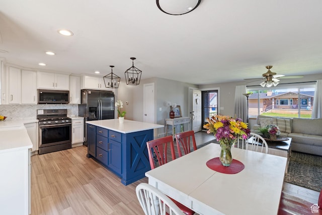1265 W 1625 S, Syracuse, UT 84075 - kitchen with appliances with stainless steel finishes, blue cabinetry, white cabinetry, light countertops, and a center island