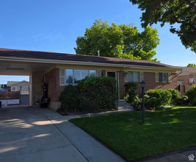 1549 W Marty Cir W, West Jordan, UT 84084 - ranch-style house with brick siding, concrete driveway, a carport, and a gate