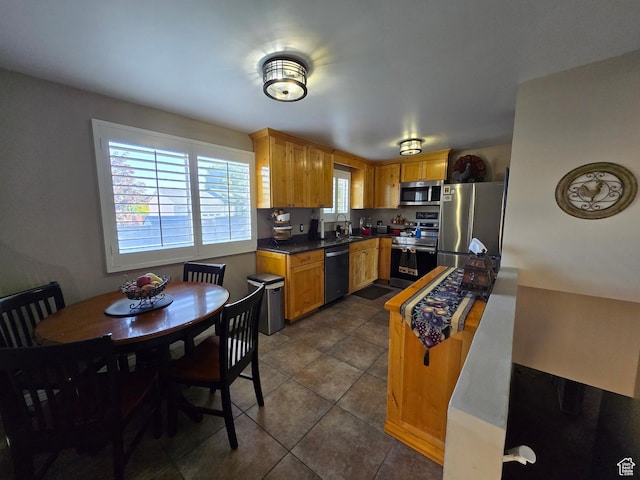 1549 W Marty Cir W, West Jordan, UT 84084 - kitchen featuring stainless steel appliances, dark tile patterned flooring, a sink, and dark countertops