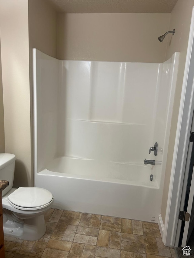4673 W Greensand Dr, West Jordan, UT 84084 - bathroom featuring stone finish floors, toilet, and bathtub / shower combination